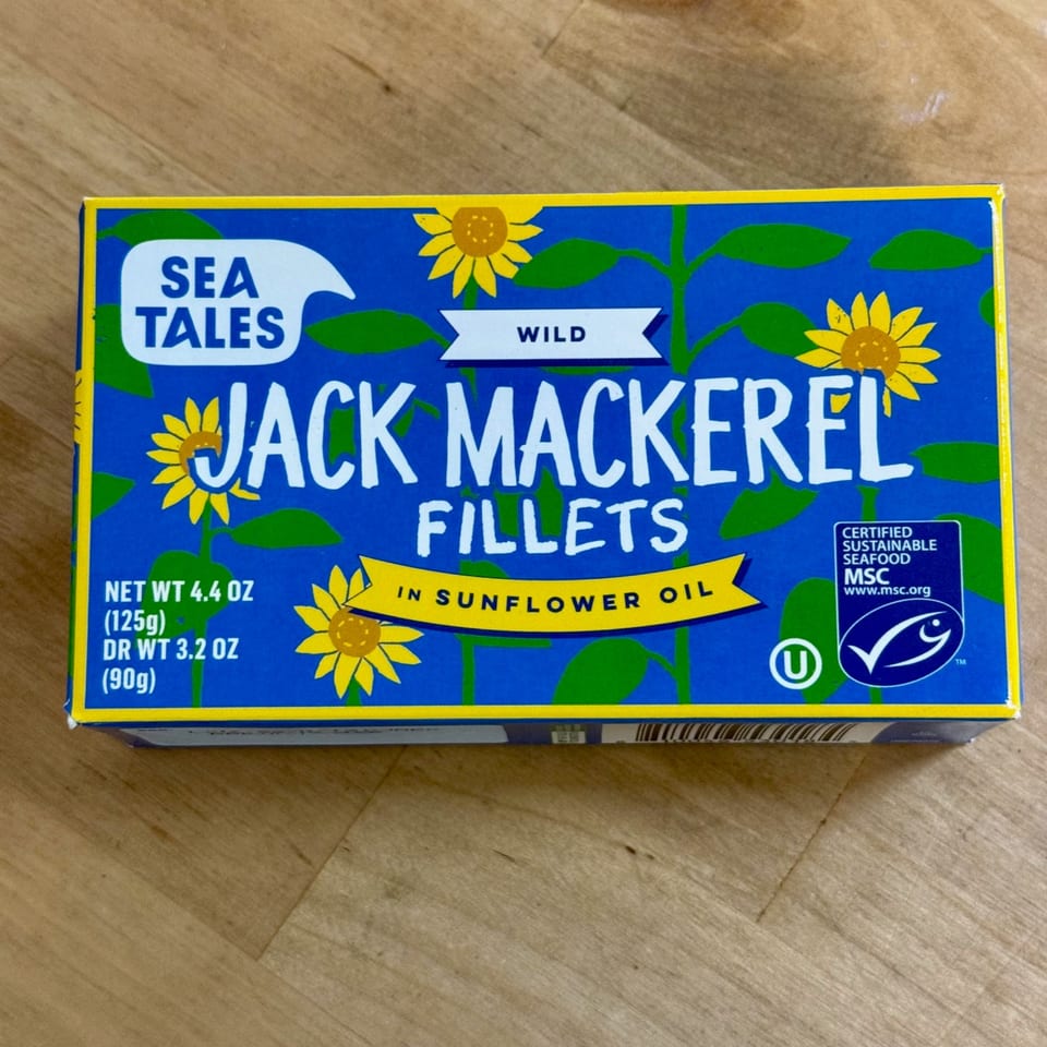 A blue box of Sea Tales Wild Jack Mackerel Fillets in Sunflower Oil, with sunflower illustrations.